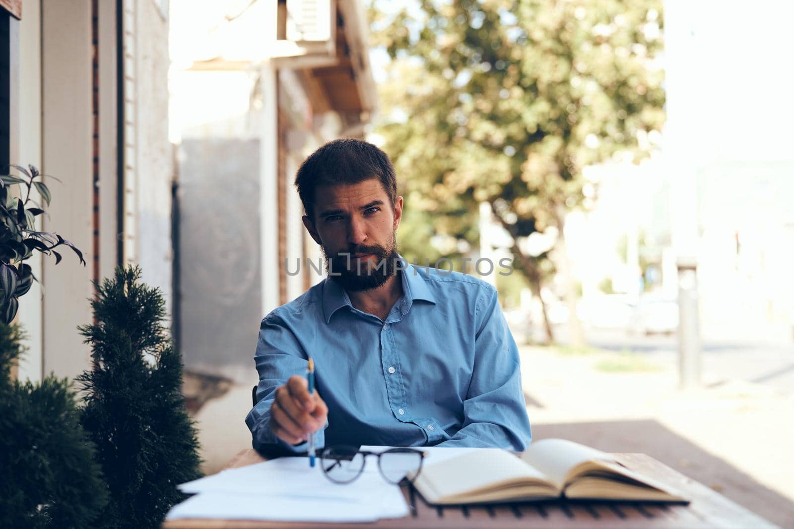 business man with papers in a summer cafe work communication by Vichizh