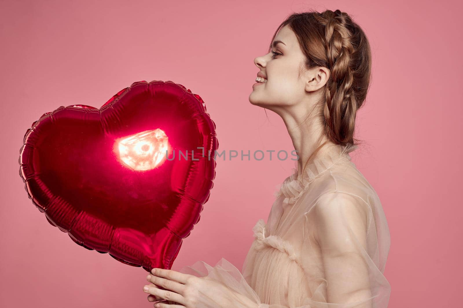 cheerful woman red heart in the hands of the balloon isolated background. High quality photo