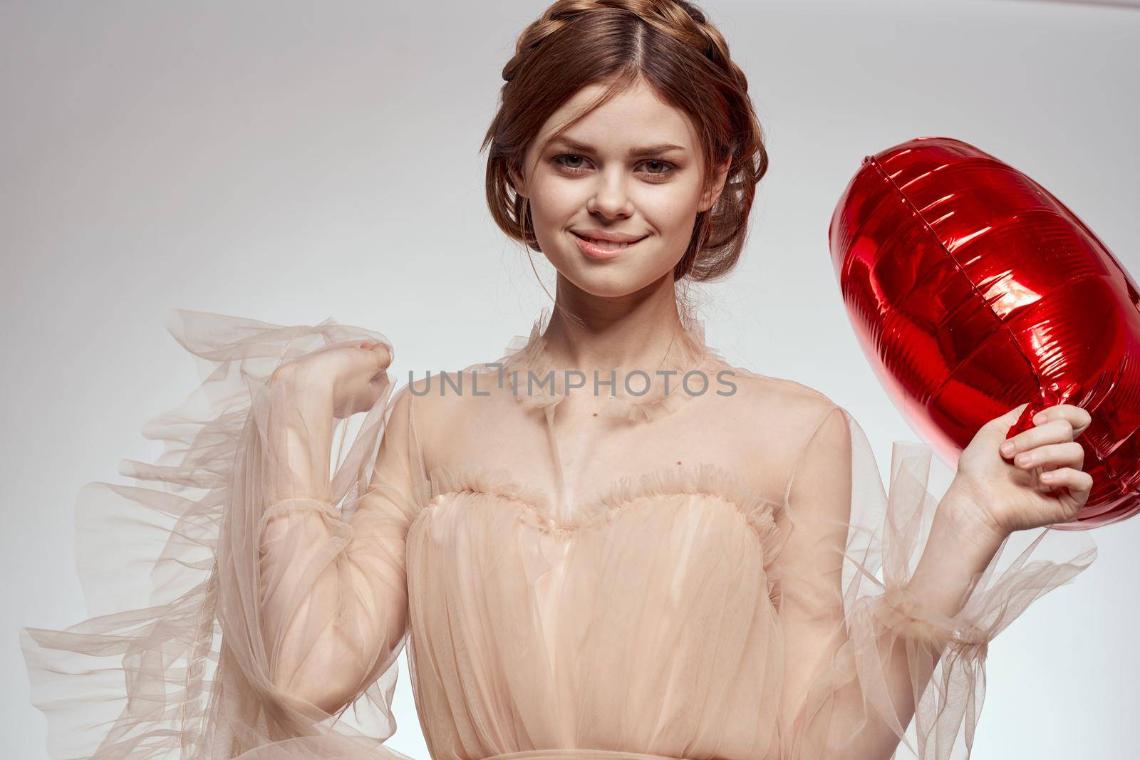 beautiful woman red heart in the hands of the balloon light background by Vichizh