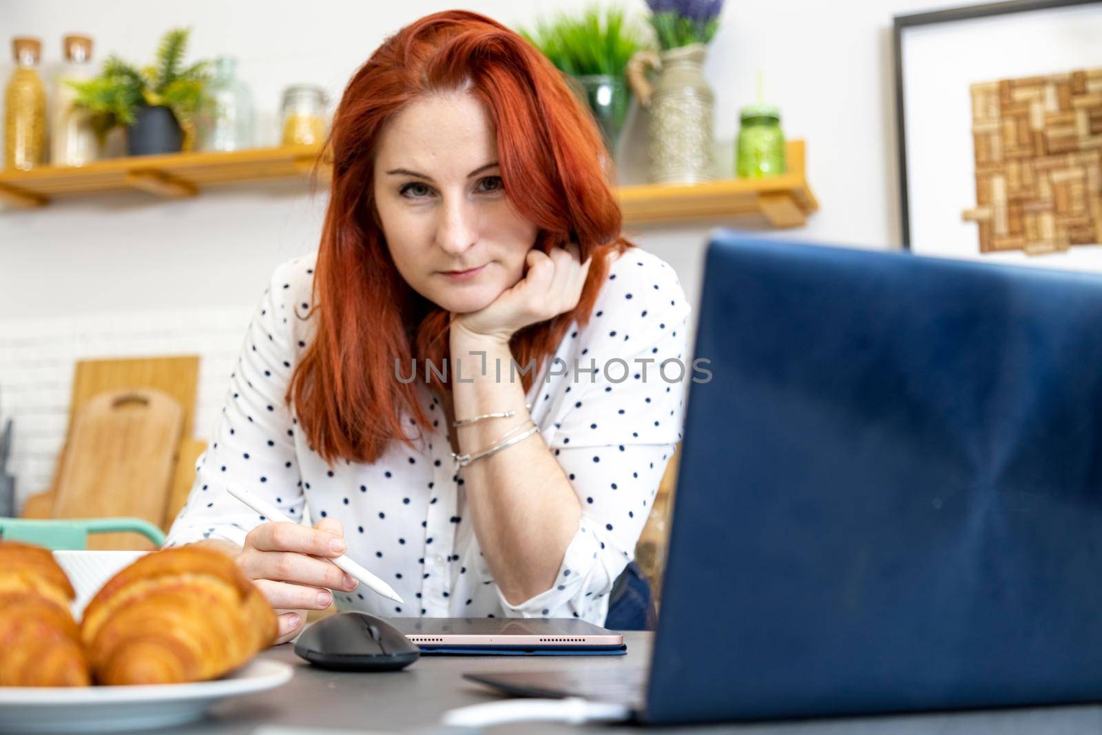 happy attractive woman working on laptop at the kitchen. beautiful woman freelancer. remote work at home