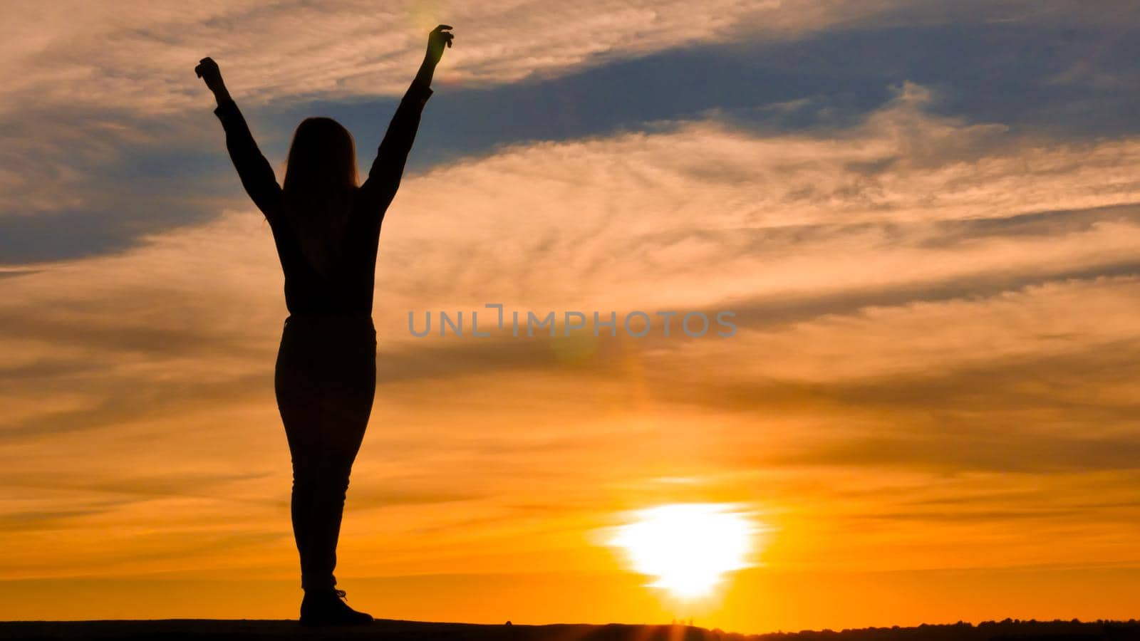 Woman silhouette with arms raised. by RecCameraStock