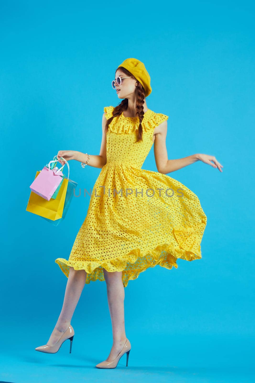 smiling woman with multicolored bags posing blue background. High quality photo