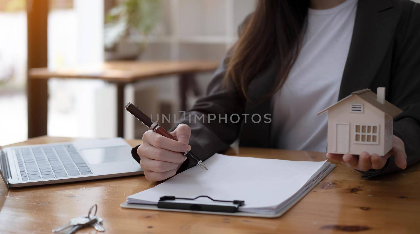 real estate realtor working in the office, reviewing rental contract on papers. Property consultant working in a modern office.