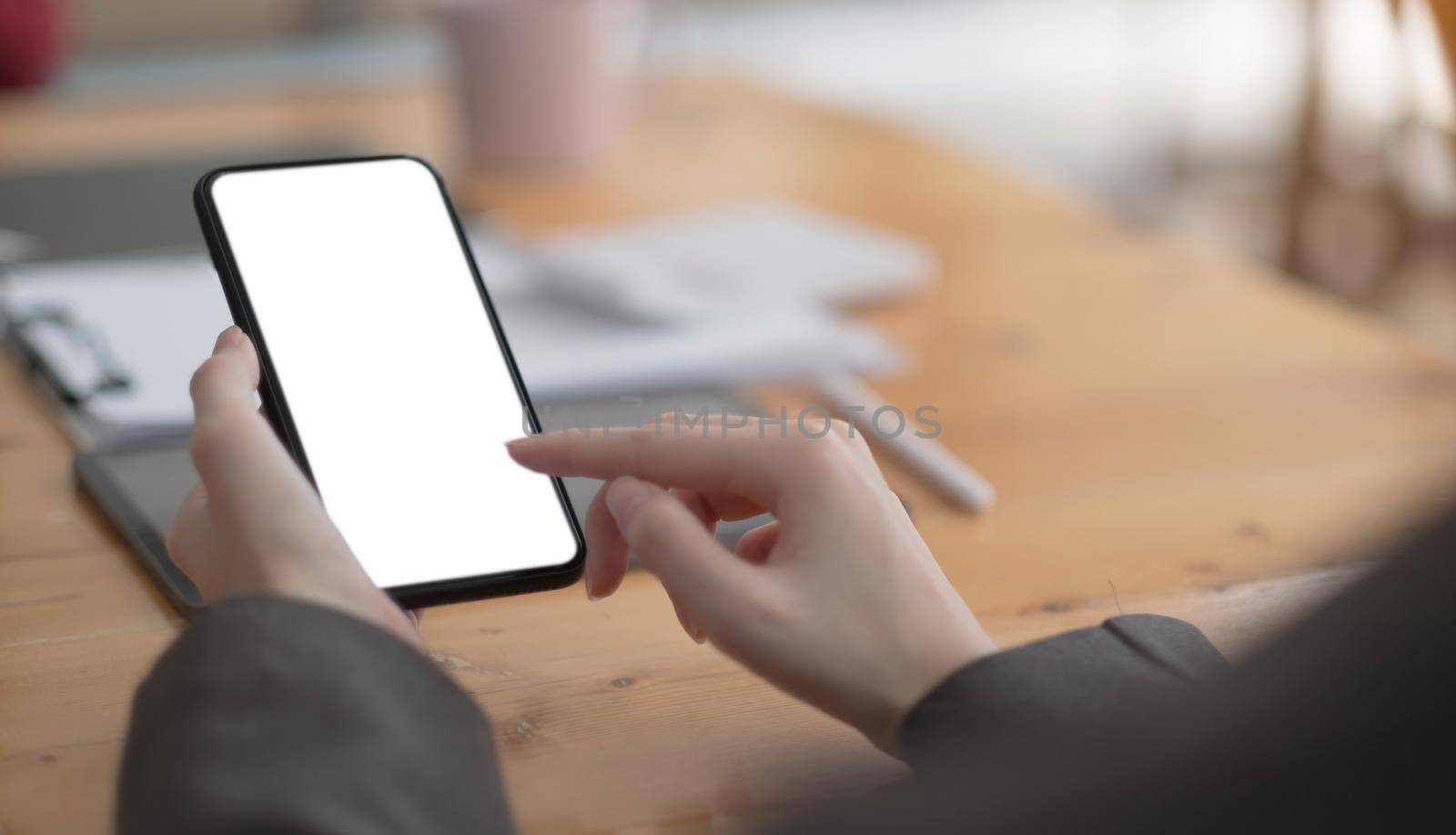 Top view Woman sitting and holding blank screen mock up mobile phone.