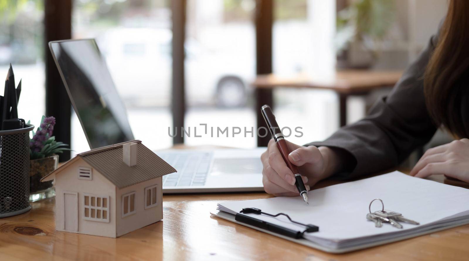 real estate realtor working in the office, reviewing rental contract on papers. Property consultant working in a modern office.