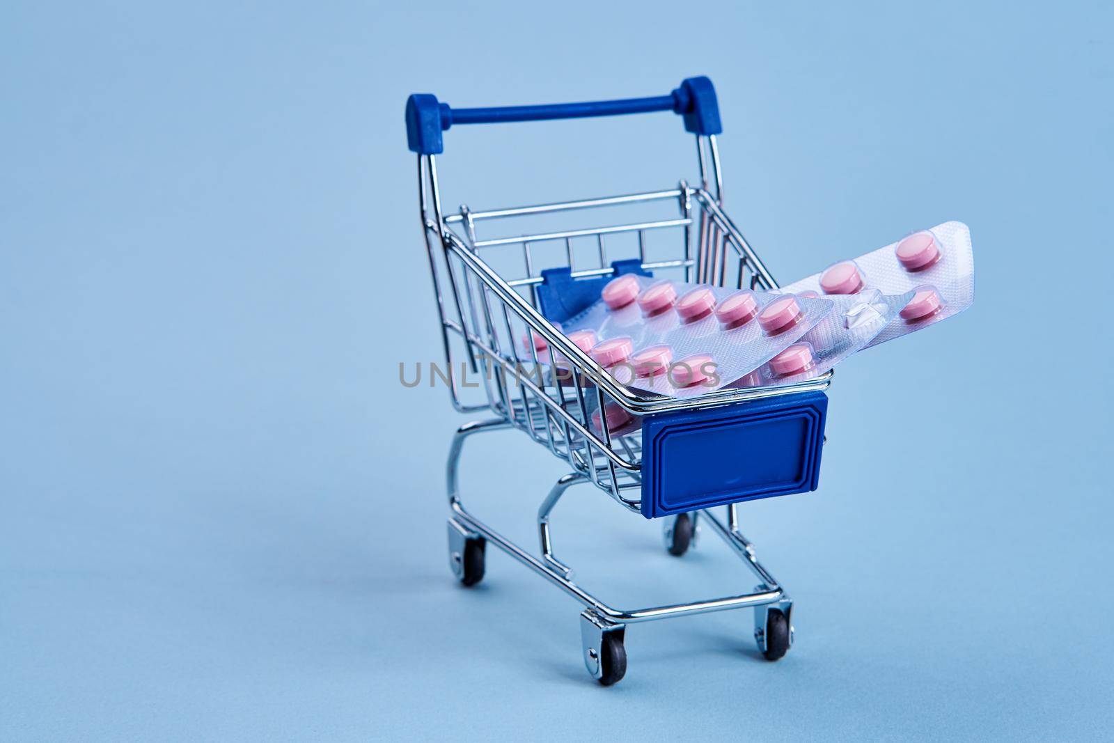 packs of pills in a trolley shopping in a pharmacy medicines by Vichizh