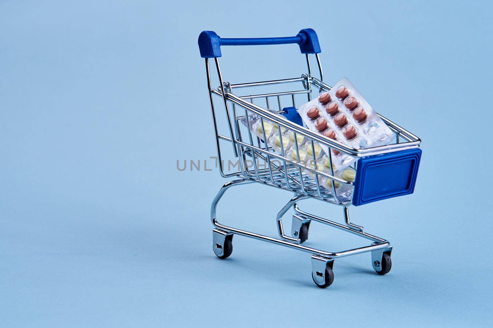 packs of pills in a trolley shopping in a pharmacy medicines by Vichizh