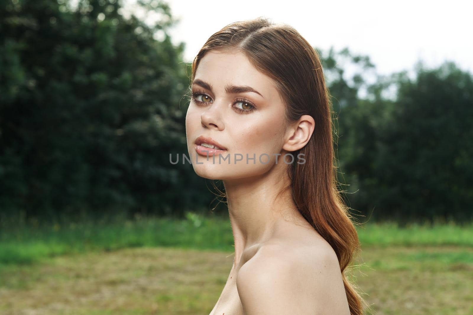 smiling woman in a field outdoors bare shoulders clear skin model. High quality photo