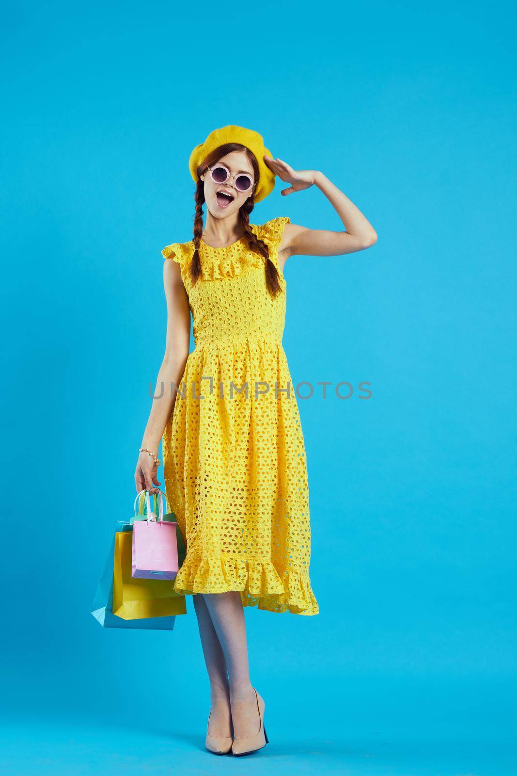 cheerful woman in a yellow hat Shopaholic fashion style studio model by Vichizh