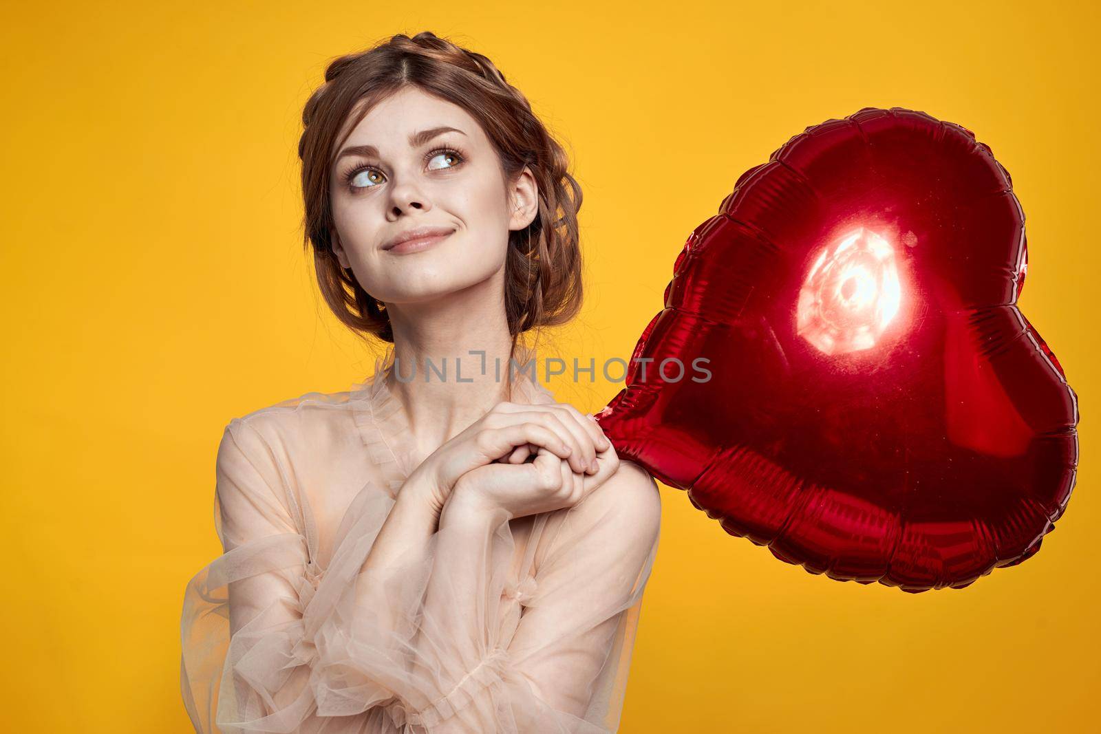 beautiful woman heart balloon holiday Valentine's Day yellow background. High quality photo