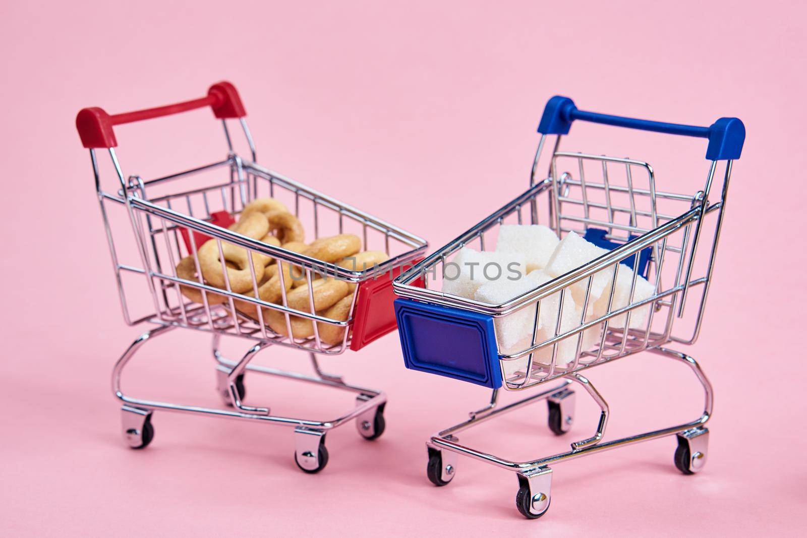 small shopping carts supermarket shopping pink background. High quality photo