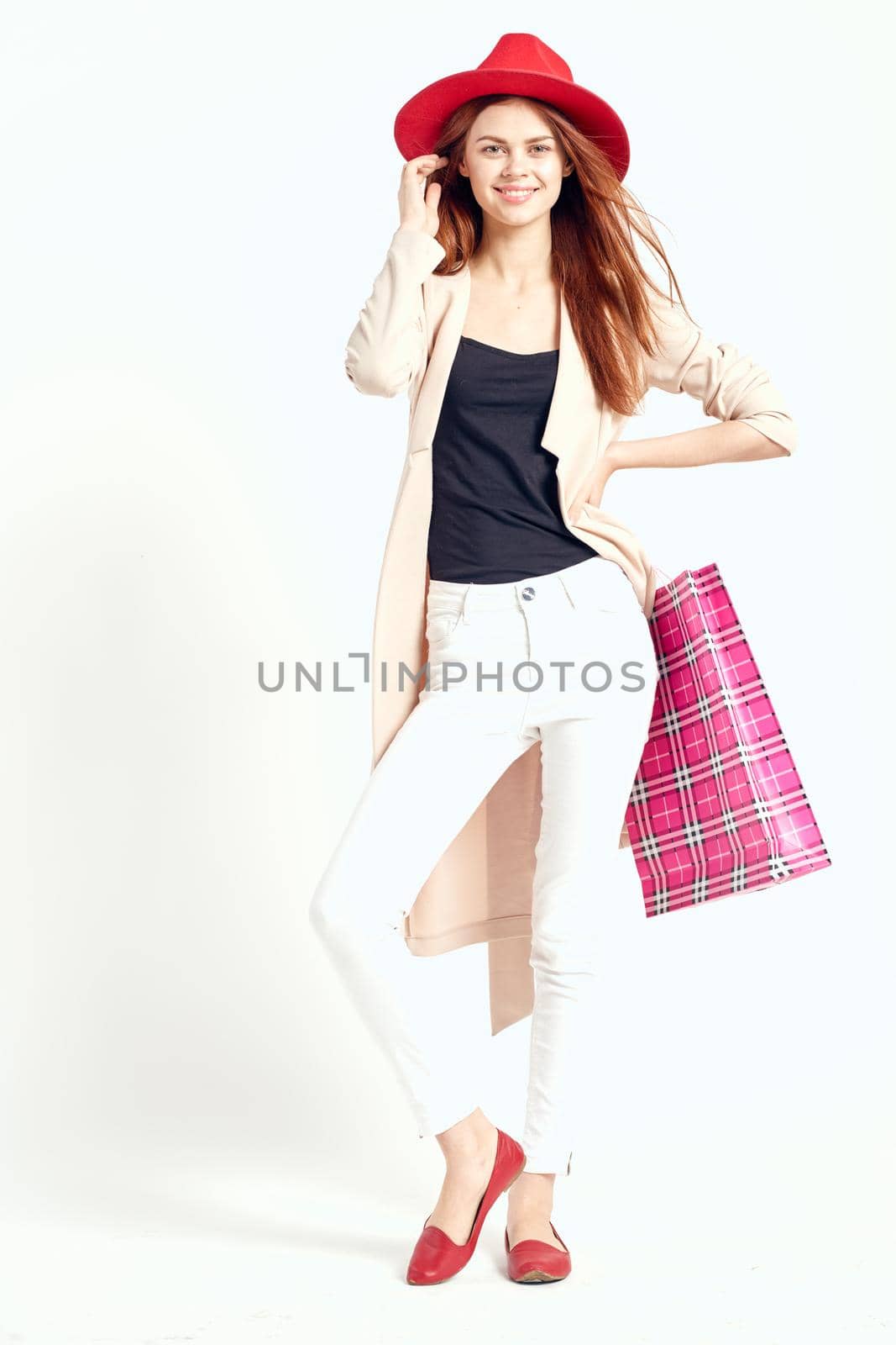 pretty woman wearing a red hat posing shopping fun studio model. High quality photo