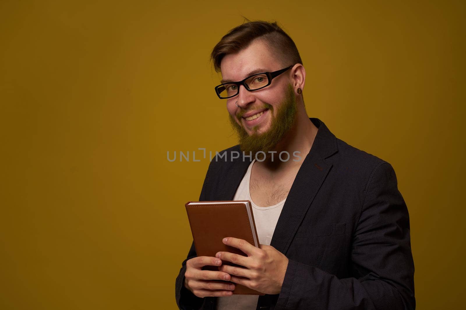 bearded man in a black jacket with a book in his hands education. High quality photo