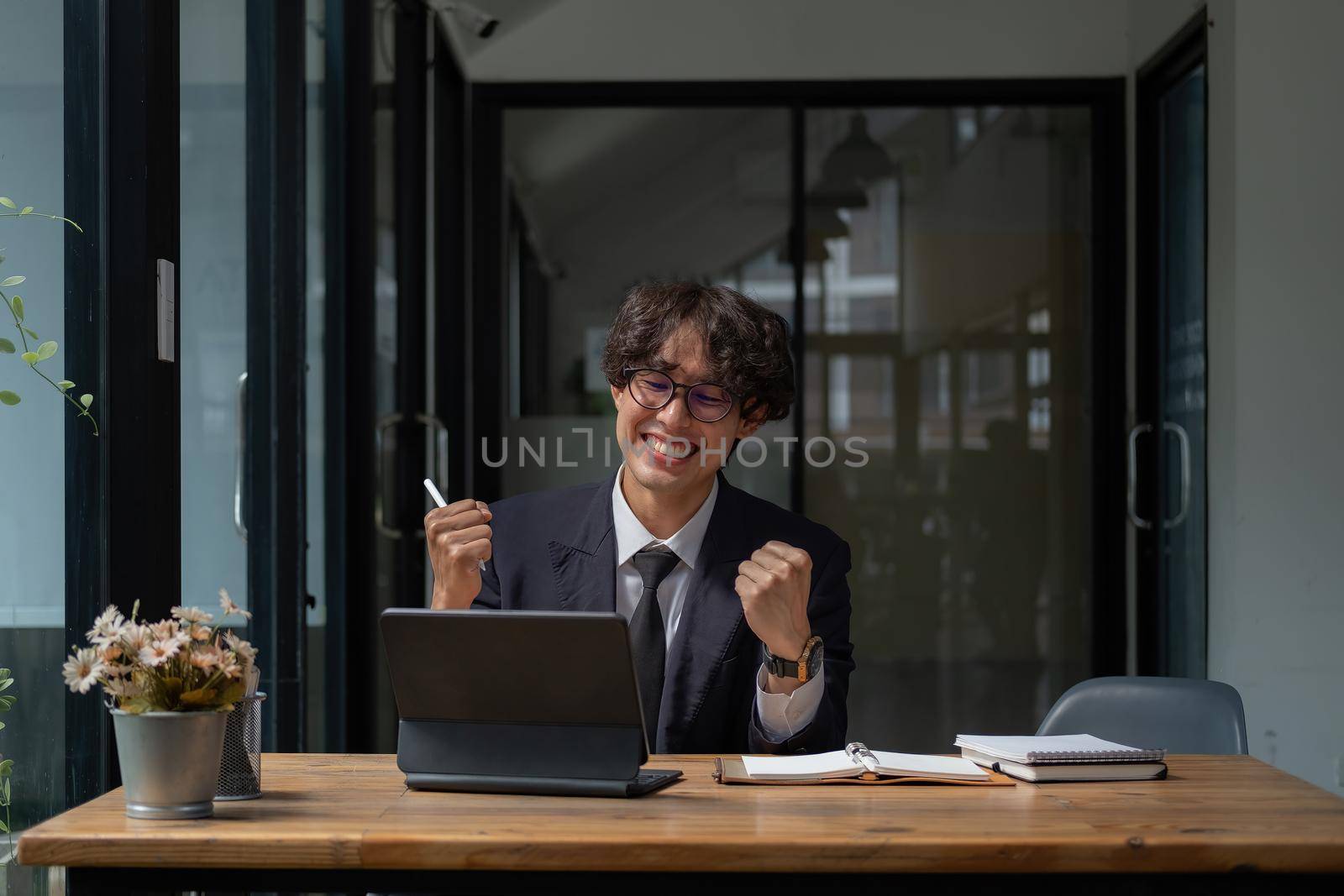 Overwhelmed by success young cheerful adult casual businessman smiling and vividly celebrating with raised hands and strong voice successful news email or business deal