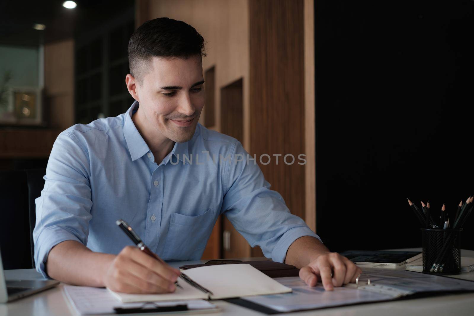 American employee working with stock trading document in home office. Business financial concept. by itchaznong