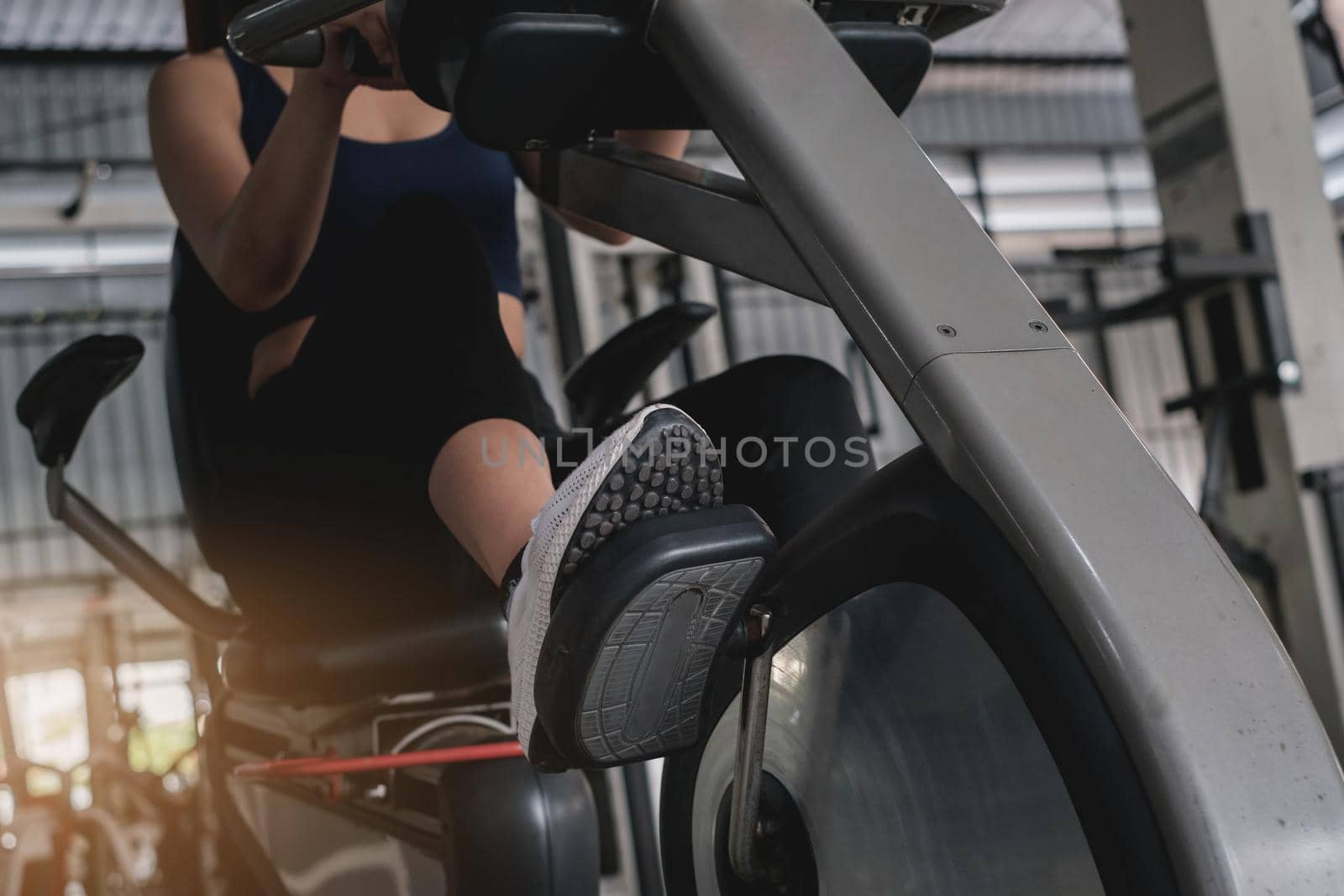 Happy young woman smiling and working out with sport biking fitness at class against fitness interface.