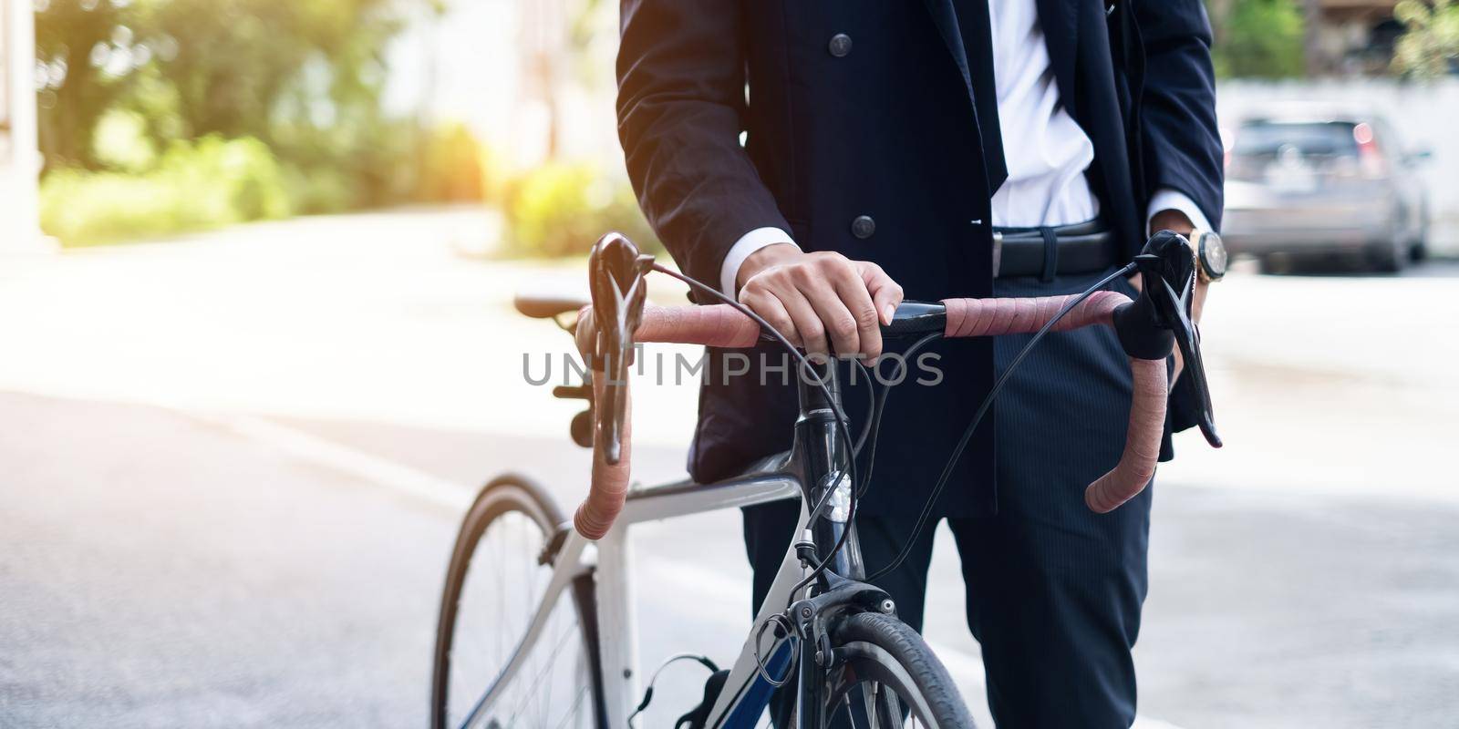 Handsome young asian businessman in suit have smiling with bicycle go to work at morning.