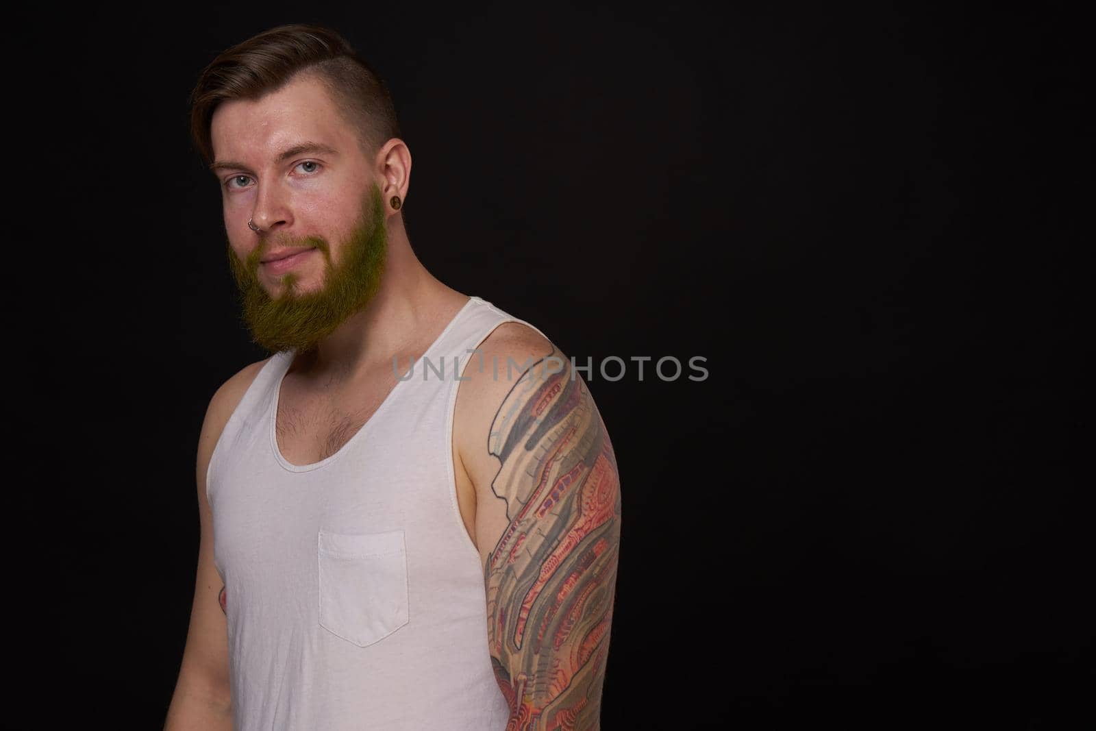 bearded man with tattoos on his arms gesturing with his hands dark background by Vichizh