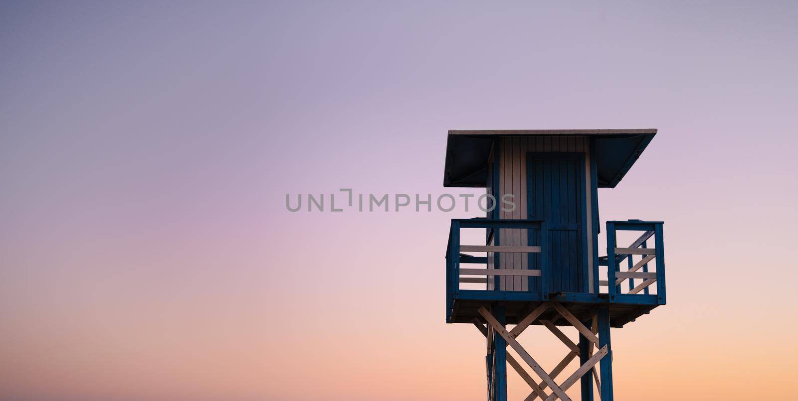 beach watchman's hut with color gradient horizon at sunset