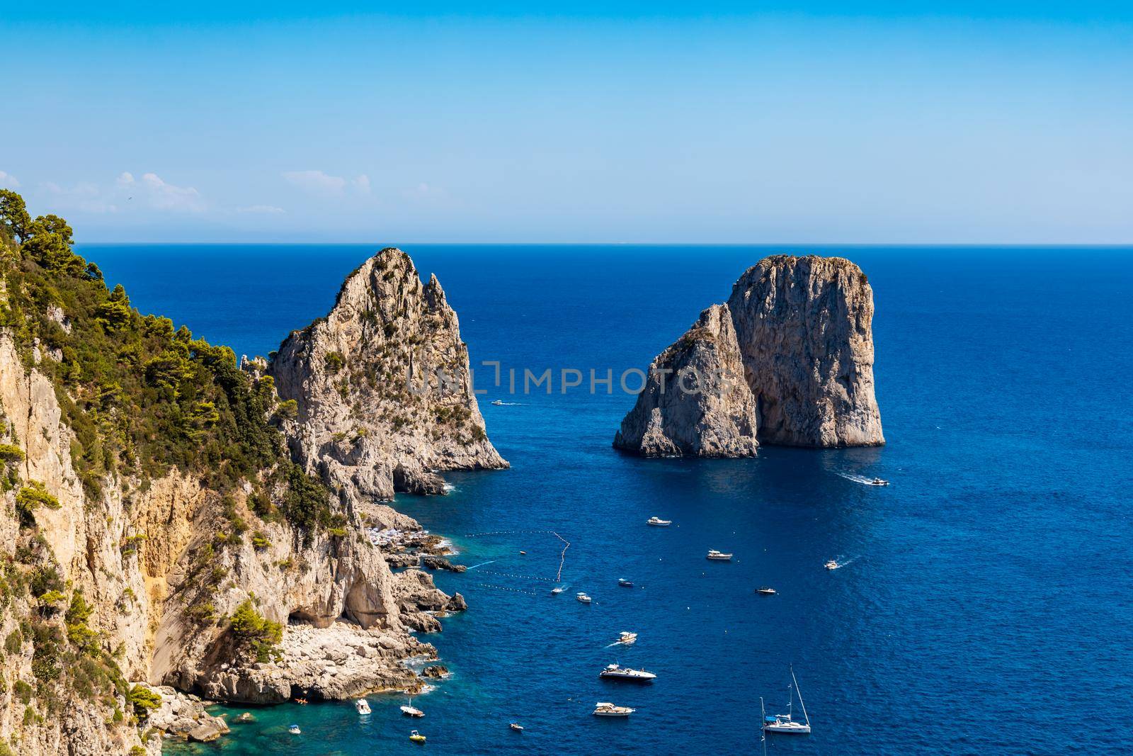 Beautiful panorama of small bay full of small ships and boats next to 
Faraglioni di Mezzo
 and Capri island  by Wierzchu