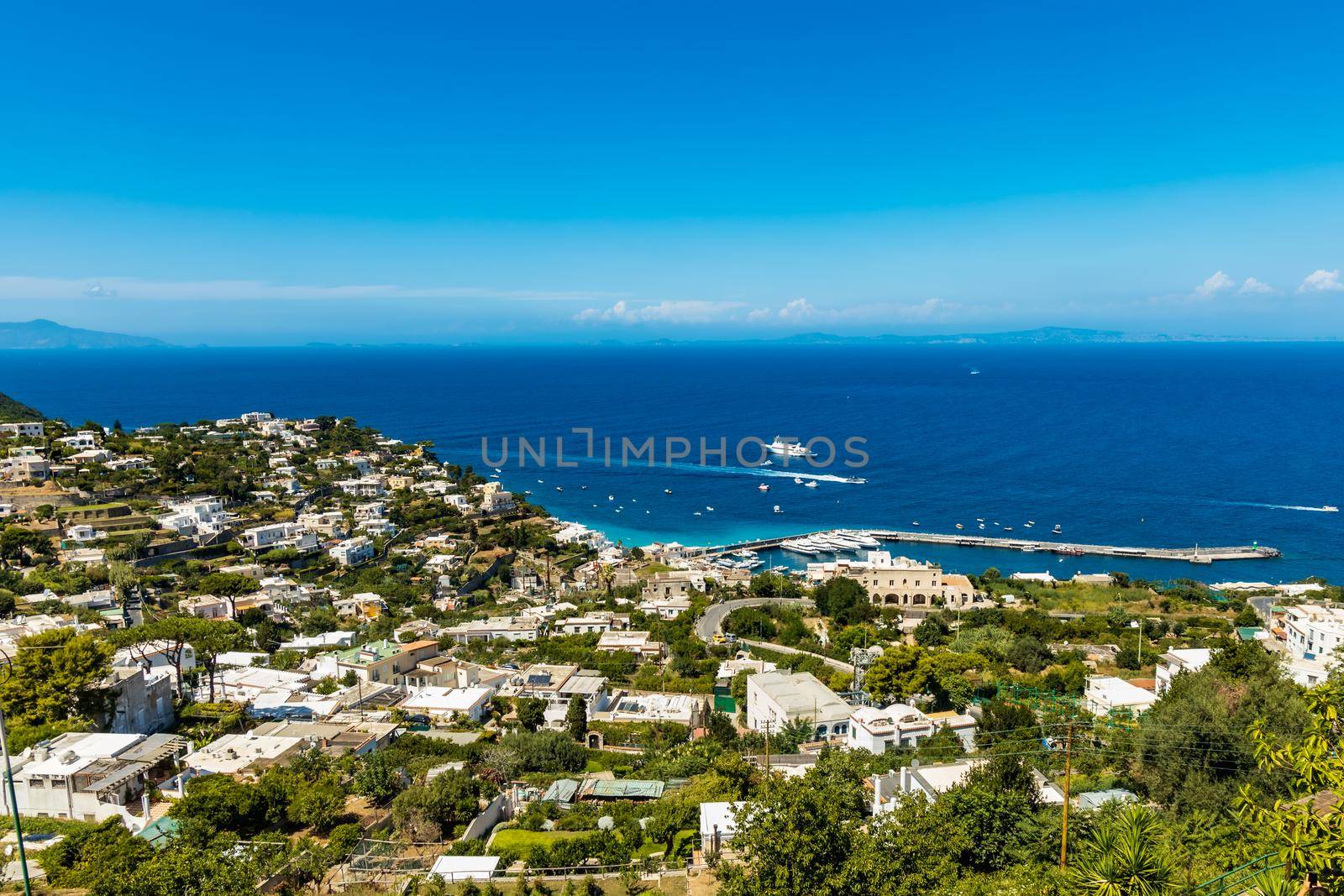 Beautiful panorama of sea and bay on Capri island full of trees and buildings by Wierzchu