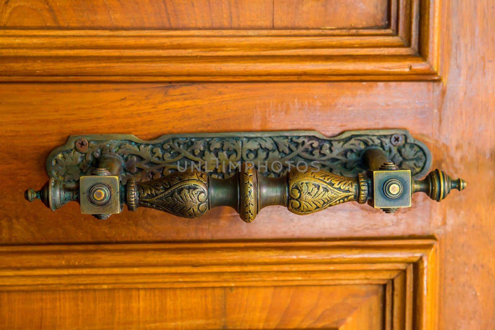 The old style door handle is made of brass or brass.