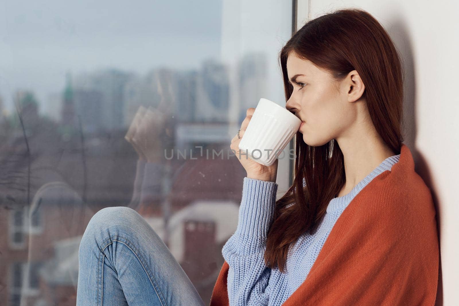woman with hot near window in plaid rest at home. High quality photo