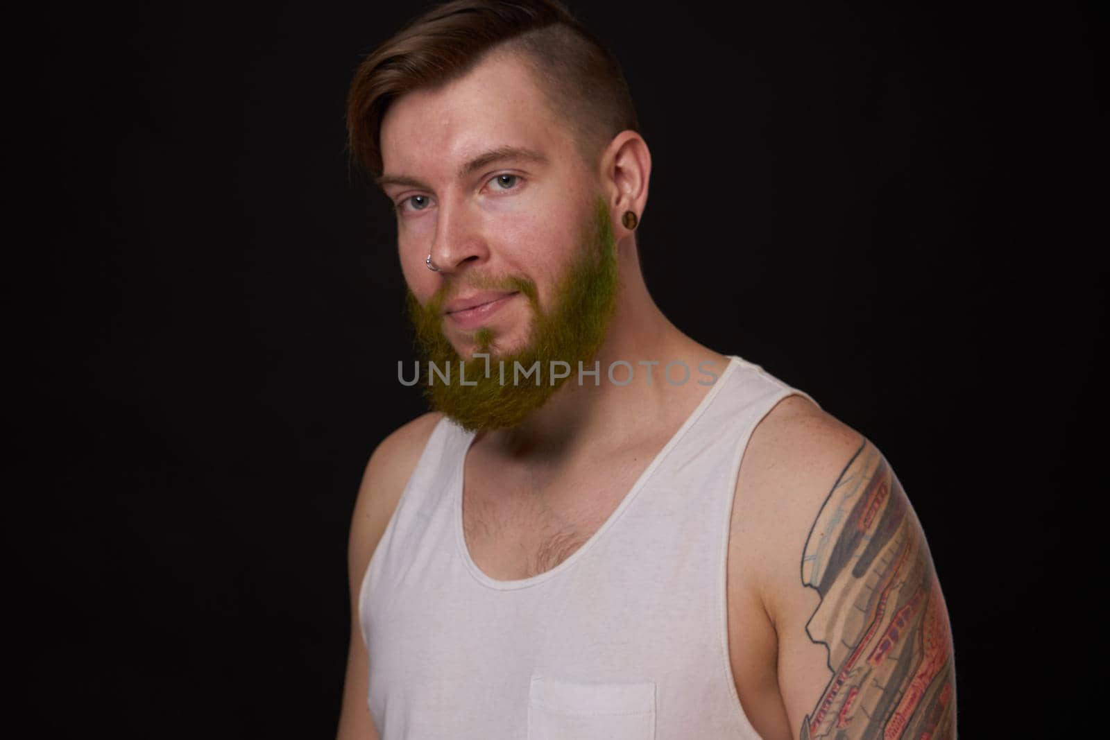 stylish bearded man in a white t-shirt with tattoos on his arms fashion. High quality photo