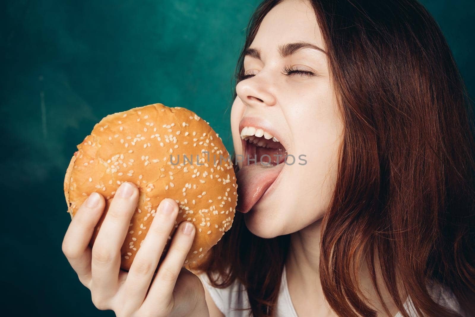 woman eating hamburger fast food snack close-up. High quality photo