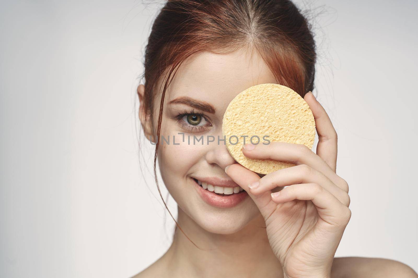 woman with a sponge in her hands bare shoulders skin care closeup. High quality photo
