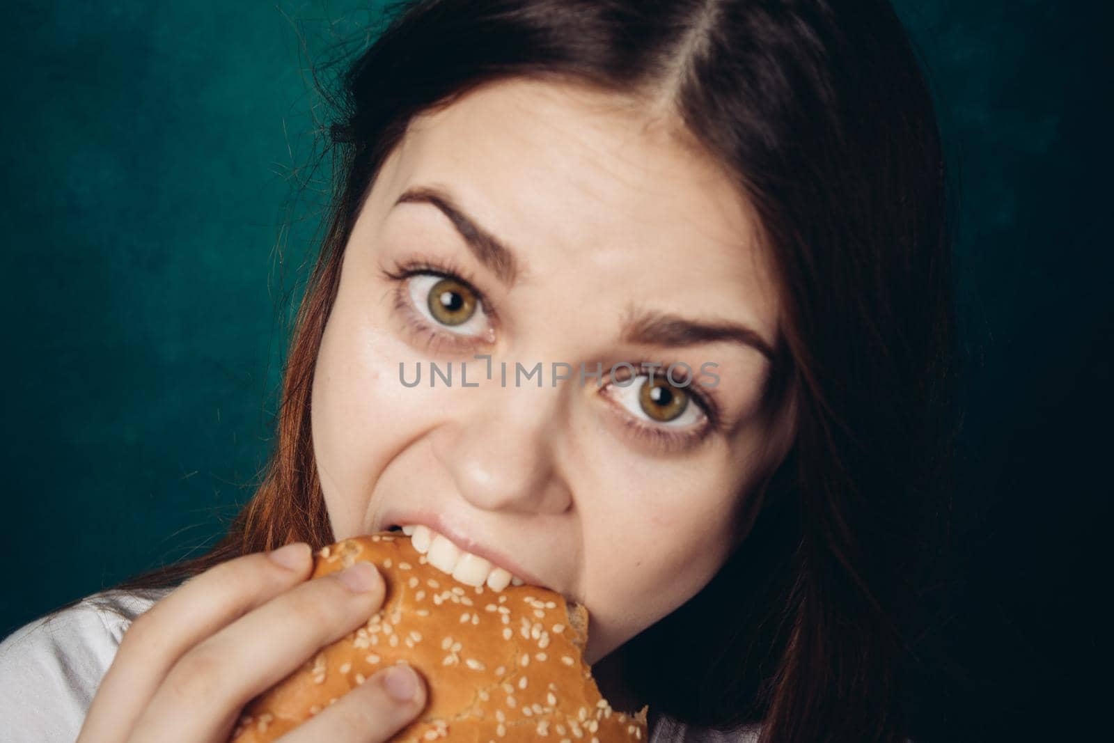 woman eating hamburger fast food snack close-up by Vichizh