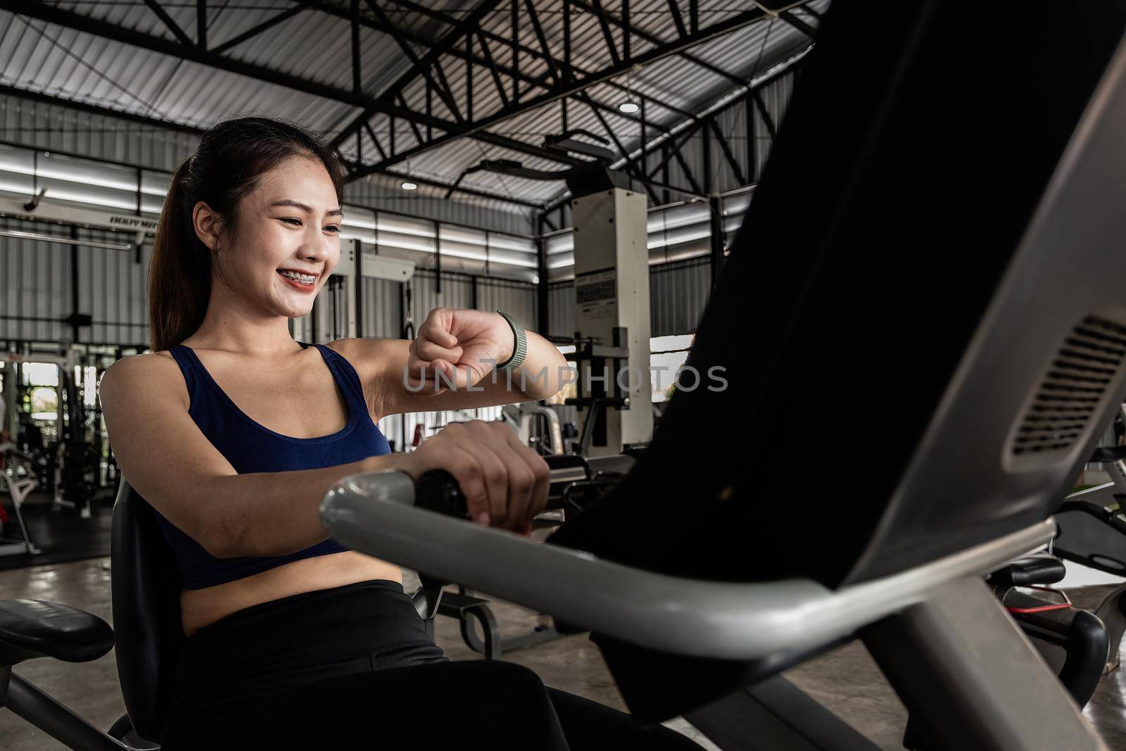 Young woman workout in gym healthy lifestyle, Woman is using smart watch during her workout with spinning or cyclo.