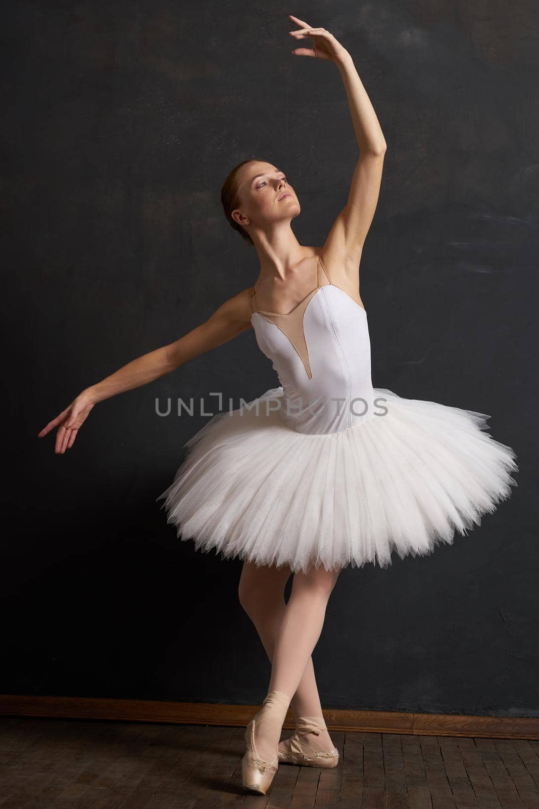 woman ballerina in a white tutu dance posing performance dark background. High quality photo