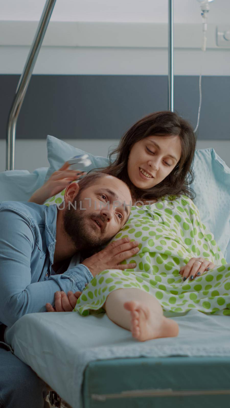 Caucasian man and woman expecting child in hospital ward by DCStudio