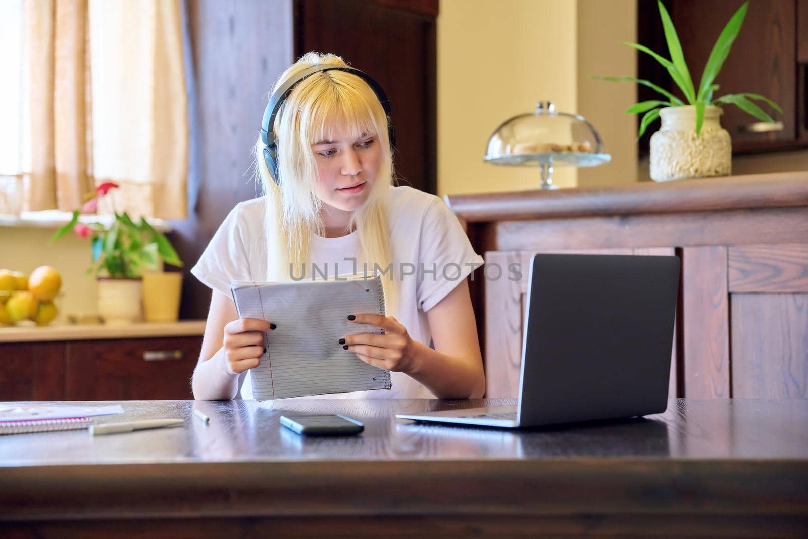 Female student in headphones using a laptop. Teenage girl studying at home, online lessons, video consultation, e-education, self-education, remote classes. Technology in education, teletechnology