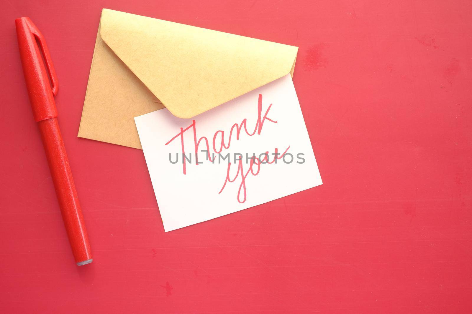 thank you message and envelope on wooden table.