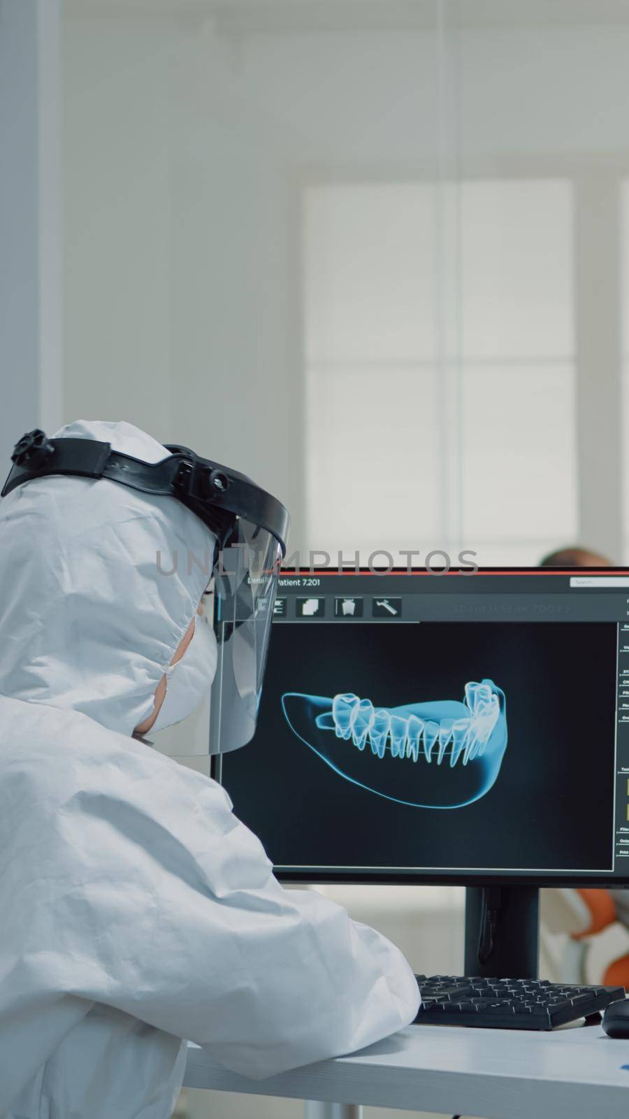 Orthodontists analyzing virtual teeth animation at oral clinic desk. Professional assistant looking at scan on computer monitor while dentist examining model for patient implant