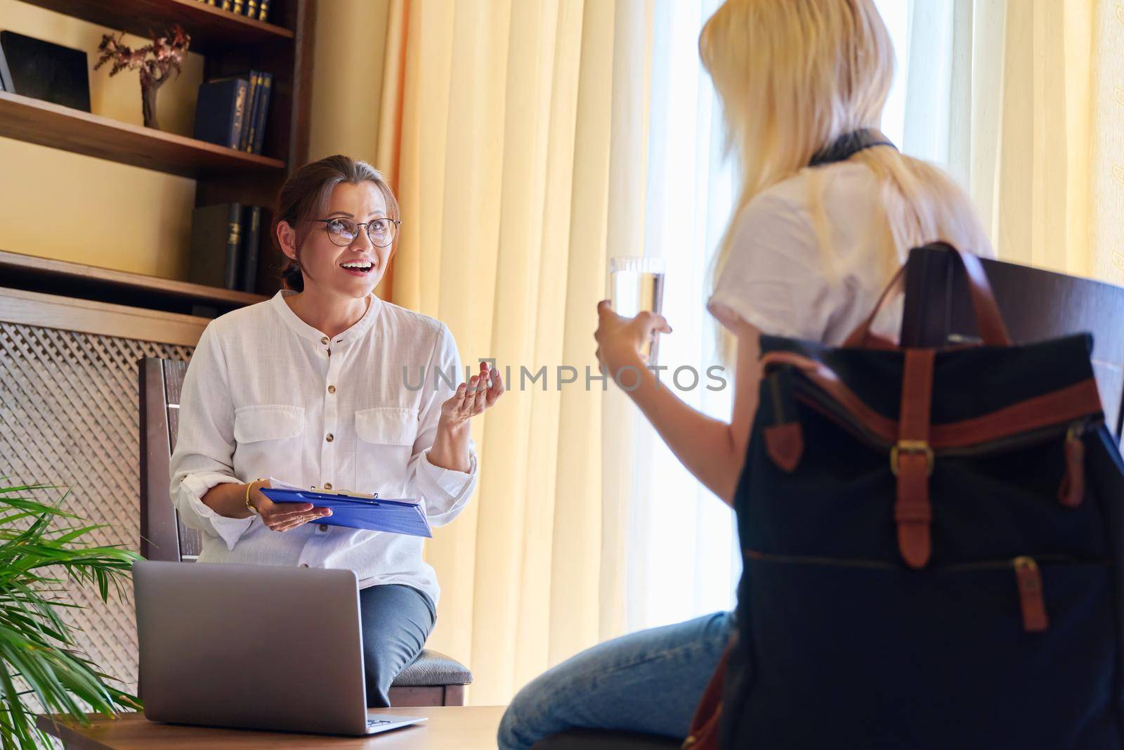 Counselor, social worker, psychologist advising a female teenager in the office by VH-studio