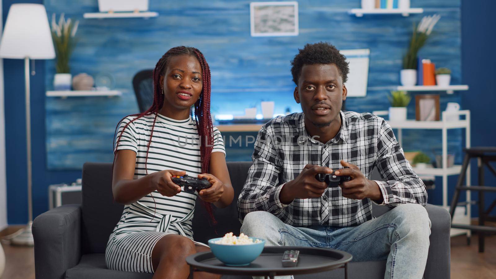 African american people playing video game with joysticks by DCStudio