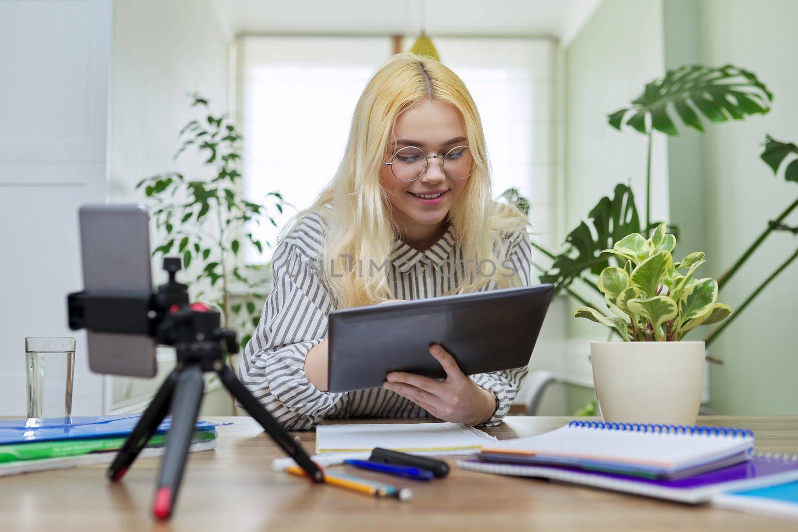 Female teenager student using digital tablet and smartphone for study by VH-studio