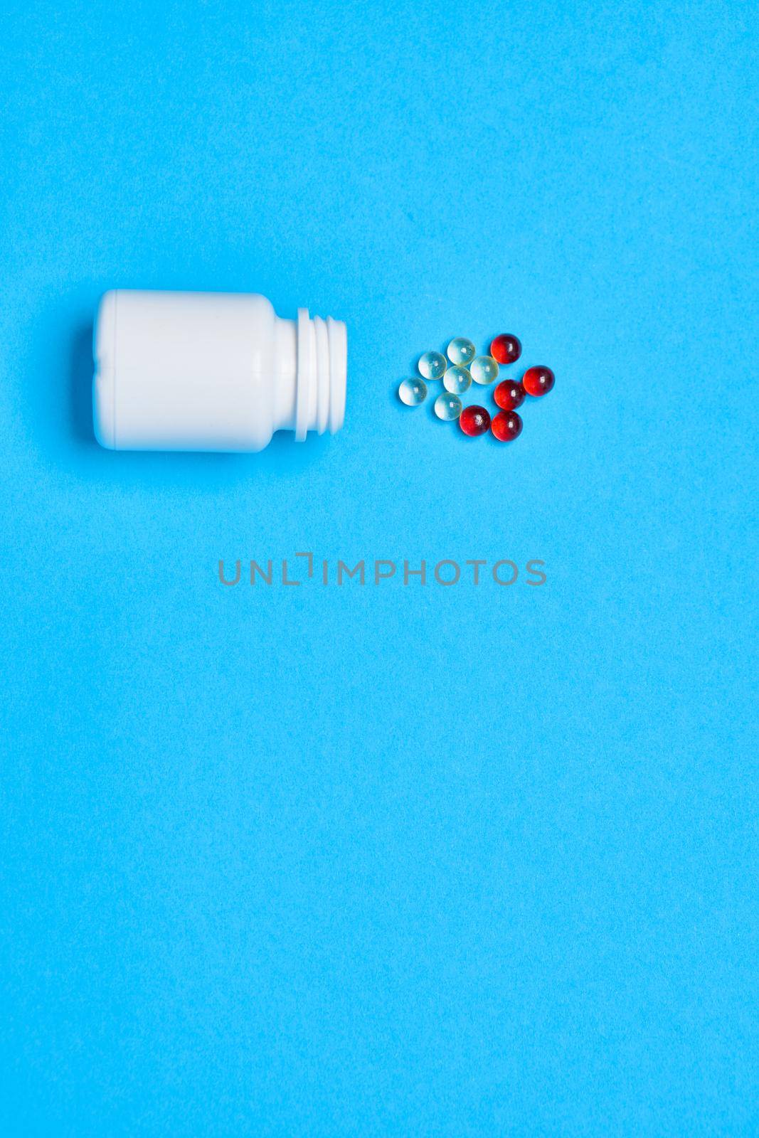 multicolored pills treatment health care blue background by Vichizh