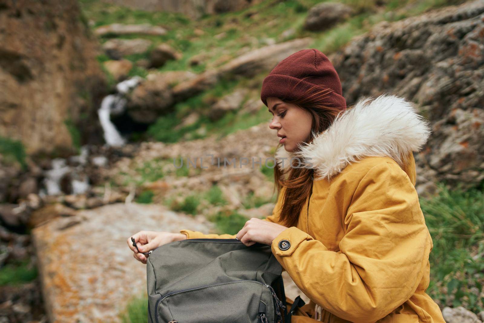 woman in yellow jacket hiking in the mountains travel adventure by Vichizh