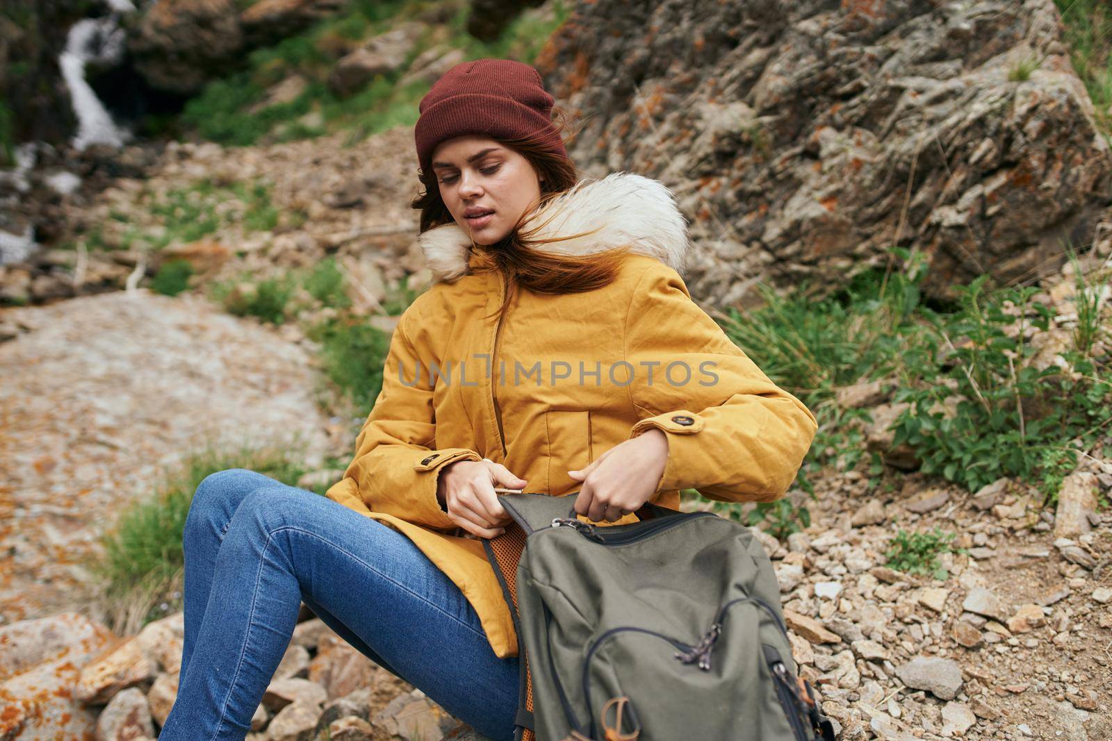 woman in yellow jacket hiking in the mountains travel adventure by Vichizh