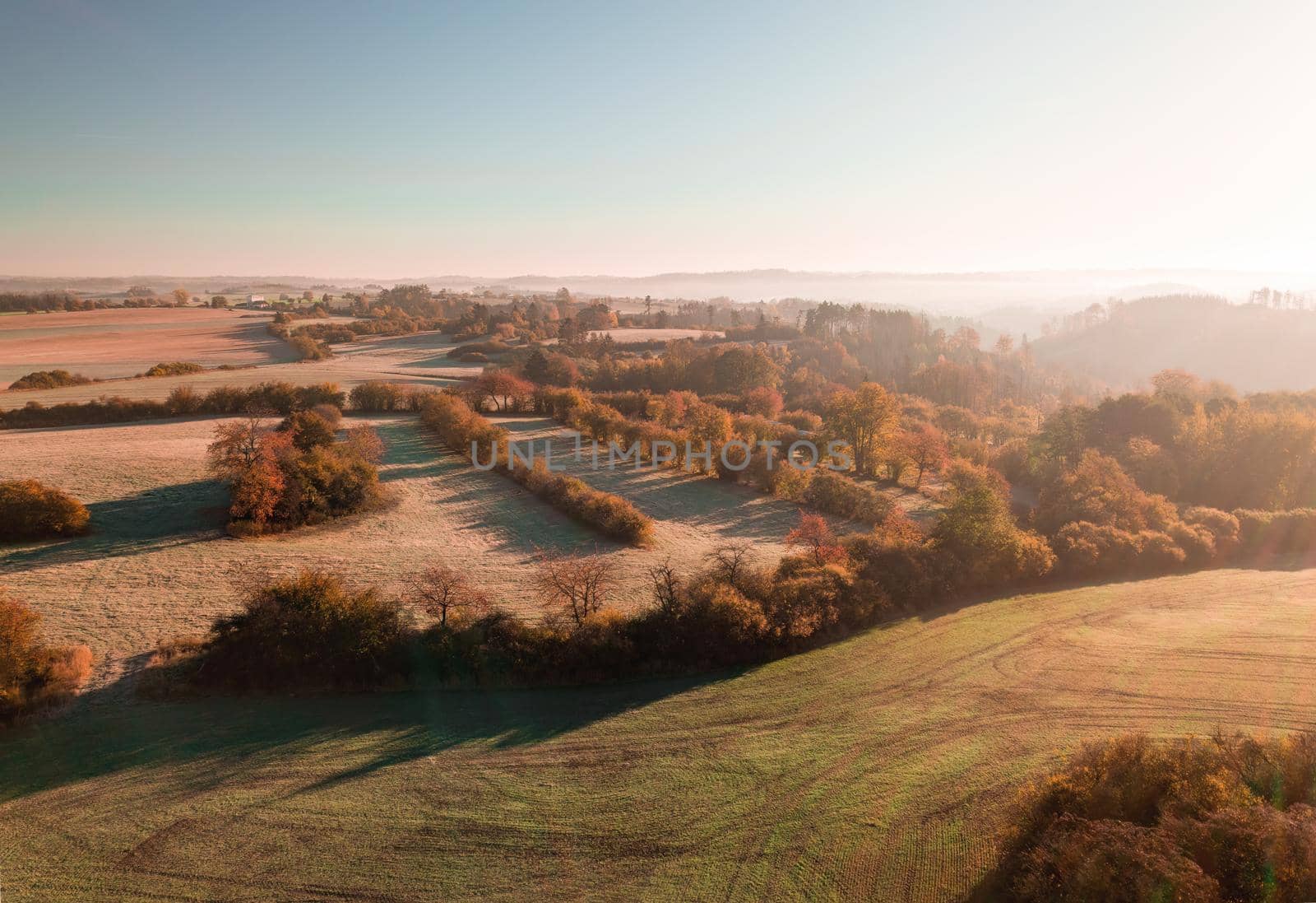 Aerial view of autumn sunrise countryside, traditional fall landscape with rising sun in Central europe. Foggy and misty sunrise. Frozen landscape from bird eye. Czech Republic,Vysocina highland