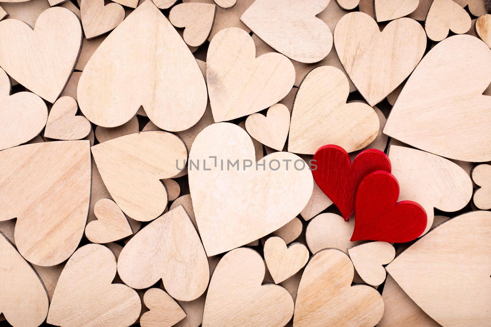 Wooden hearts, one red heart on the wooden heart background.	




