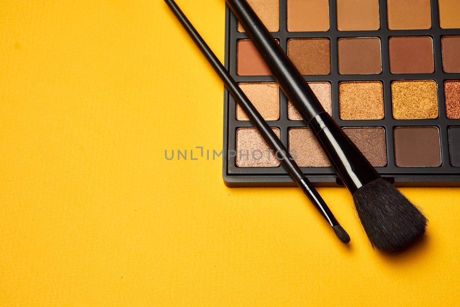 cosmetics mascara brushes decoration accessories yellow background. High quality photo