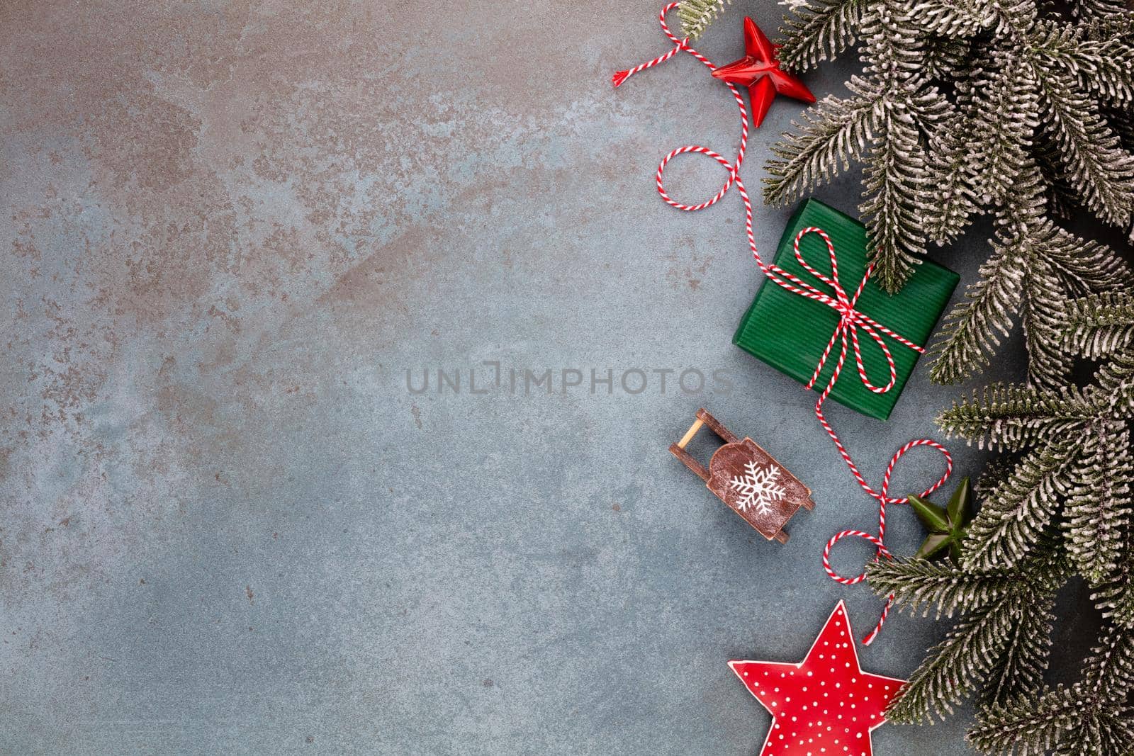 Christmas composition fir tree branches, star ornaments on blue background. by gitusik
