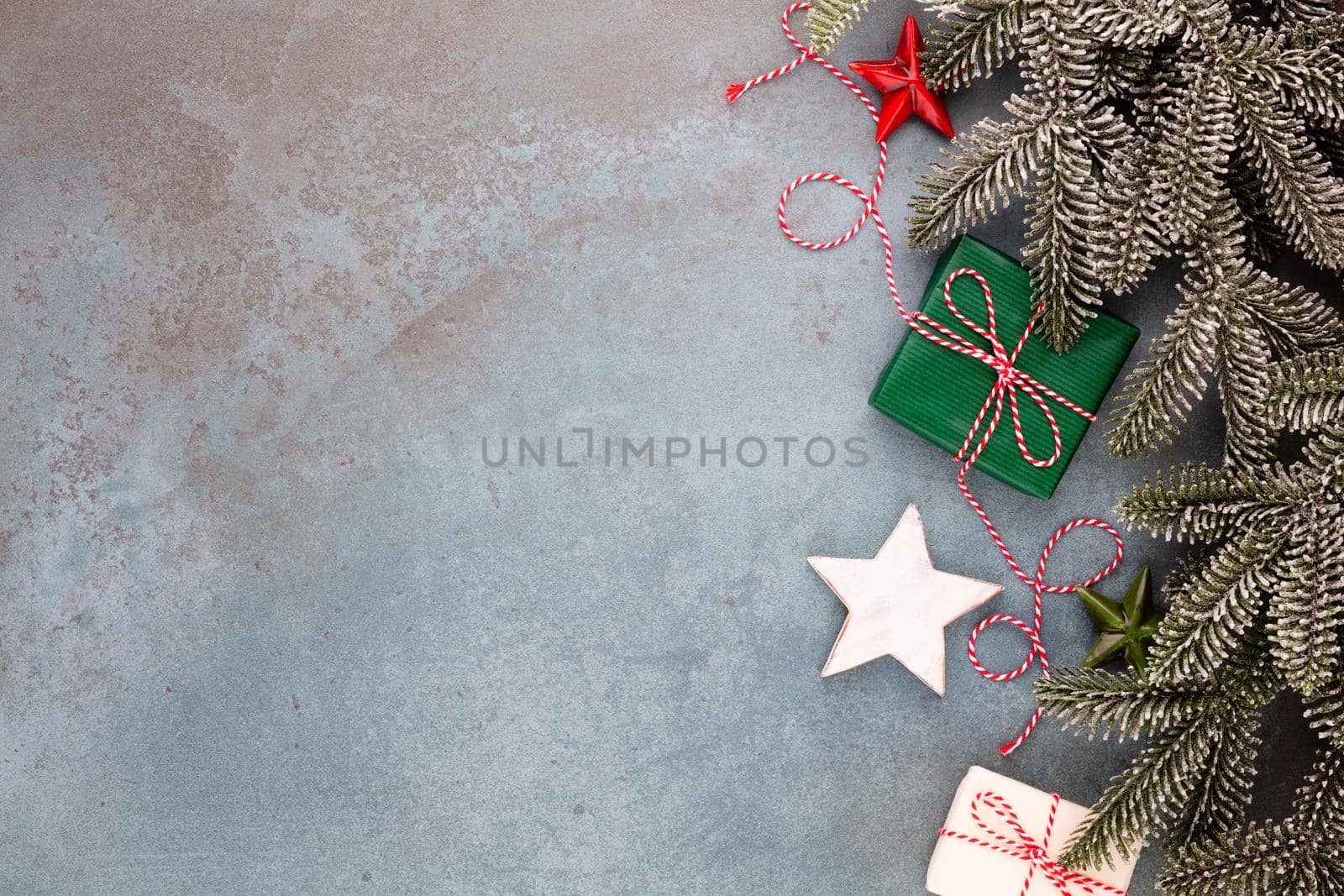 Christmas composition fir tree branches, star ornaments on blue background. by gitusik