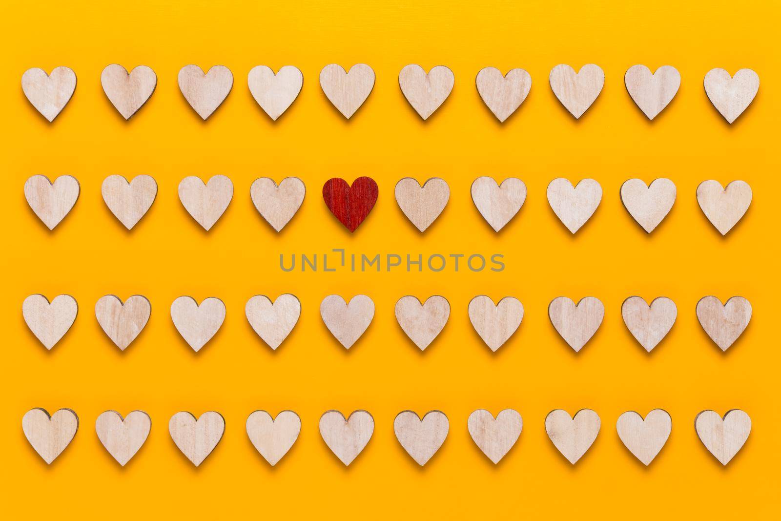 Small wooden hearts on a yellow background. A creative idea. Valentine day greeting card.