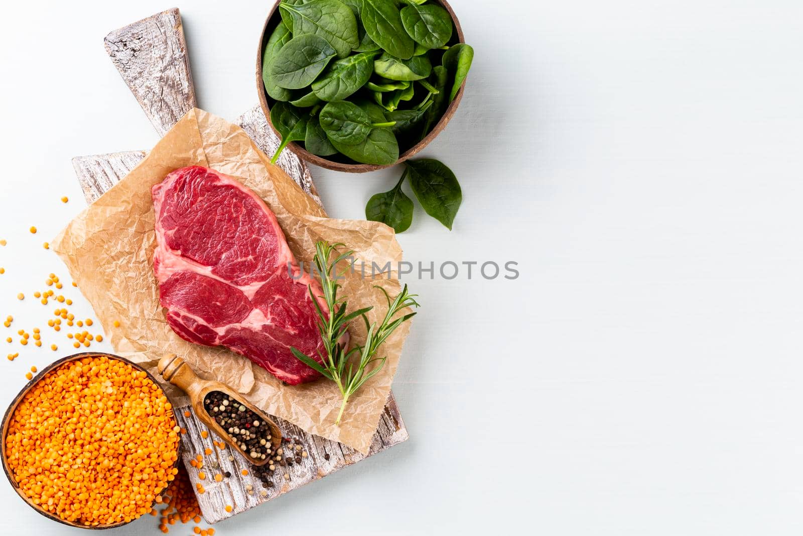 Fresh raw rib-eye steak on wooden cutting board. by gitusik